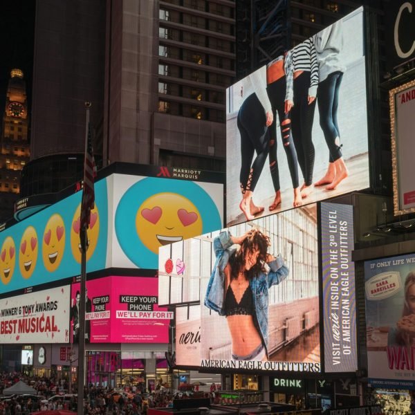 Colorful billboards light up New York City's iconic Times Square at night, with vibrant ads and bustling crowds.
